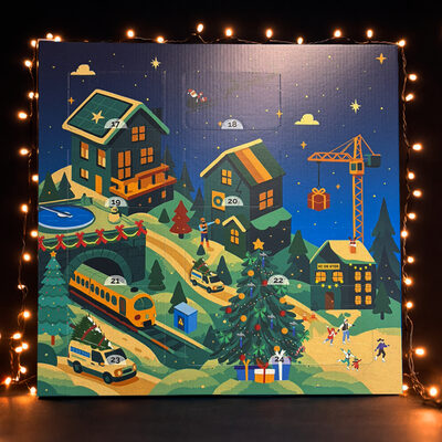 De adventskalender voor Hegeman: een geïllustreerd winterdorp met huizen, een trein, een bouwkraan en genummerde vakjes, omringd door lichtjes.