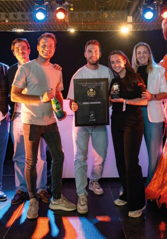 Het team van Amigo op het podium met de ingelijste oorkonde 'Leverancier van het Jaar – Nederland 2025, categorie 1 t/m 5 werknemers' en de award in handen.