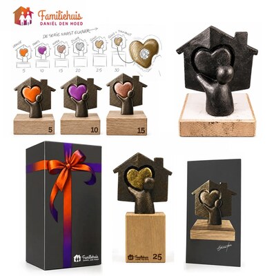 De ontwerpschets en de uitvoeringen van het sculptuur voor Familiehuis Daniël den Hoed: een figuurtje dat een gekleurd hart omhooghoudt in een huisje, met de jubileumjaren op de sokkel.