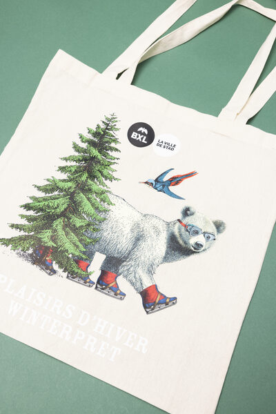 Een linnen tote bag met een schaatsende beer, een dennenboom en een vogel, het BXL-logo en de tekst 'Plaisirs d'Hiver / Winterpret'.